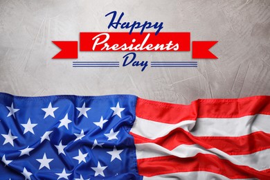 Image of Happy President's Day - federal holiday. American flag and text on grey stone background, top view