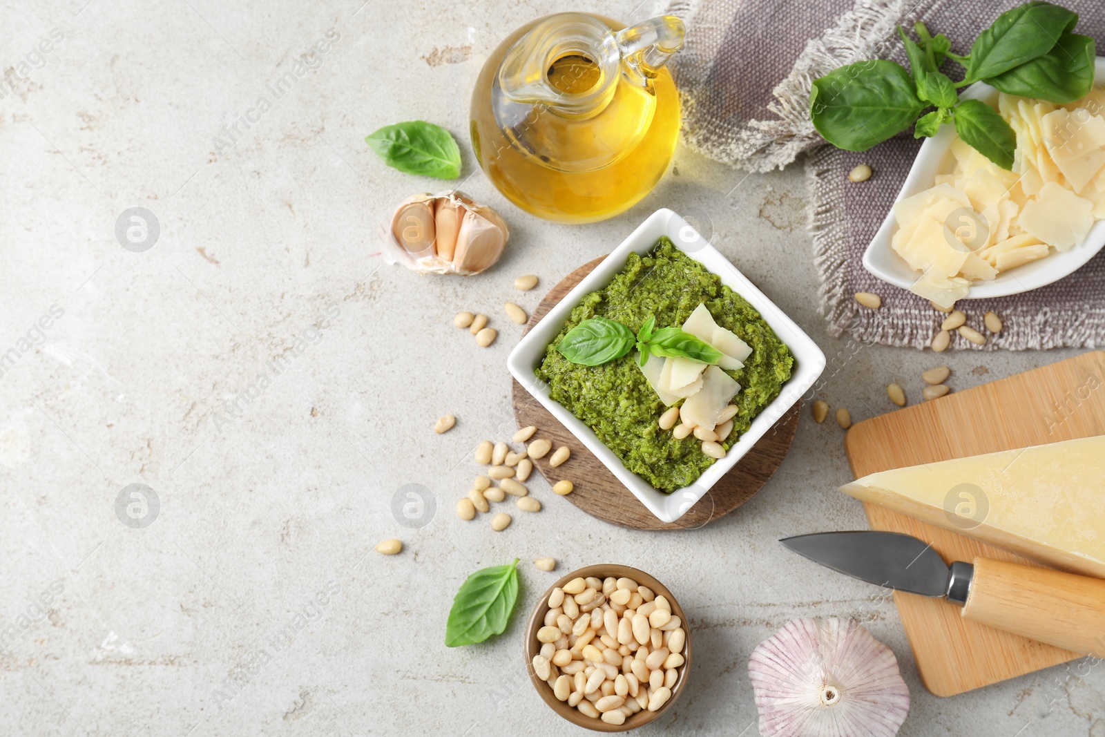 Photo of Delicious pesto sauce and ingredients on light table, flat lay. Space for text