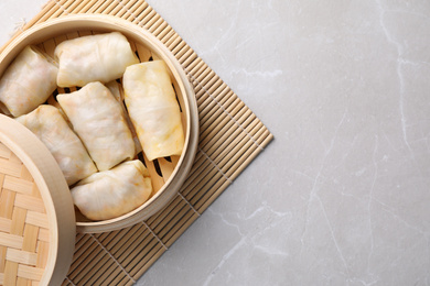 Photo of Delicious cabbage rolls served on light grey marble table, top view. Space for text