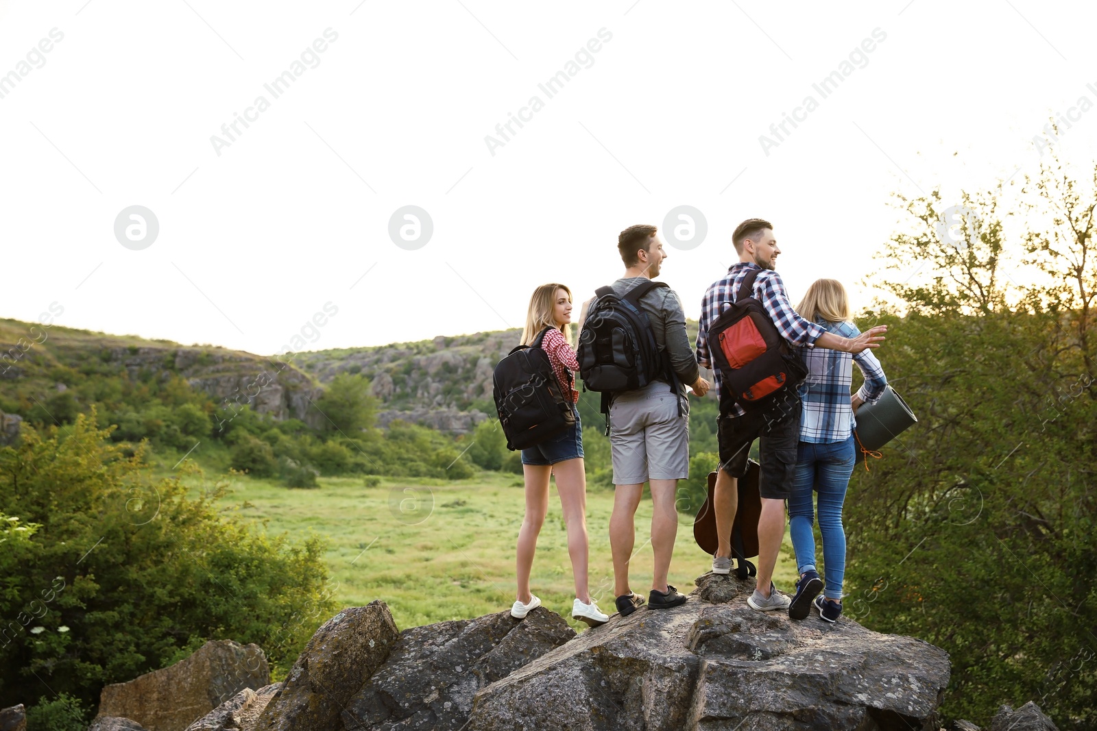 Photo of Group of young people with backpacks in wilderness. Camping season