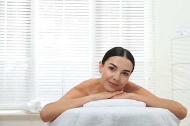 Beautiful young woman relaxing in spa salon