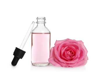 Photo of Bottle of rose essential oil, pipette and flower isolated on white