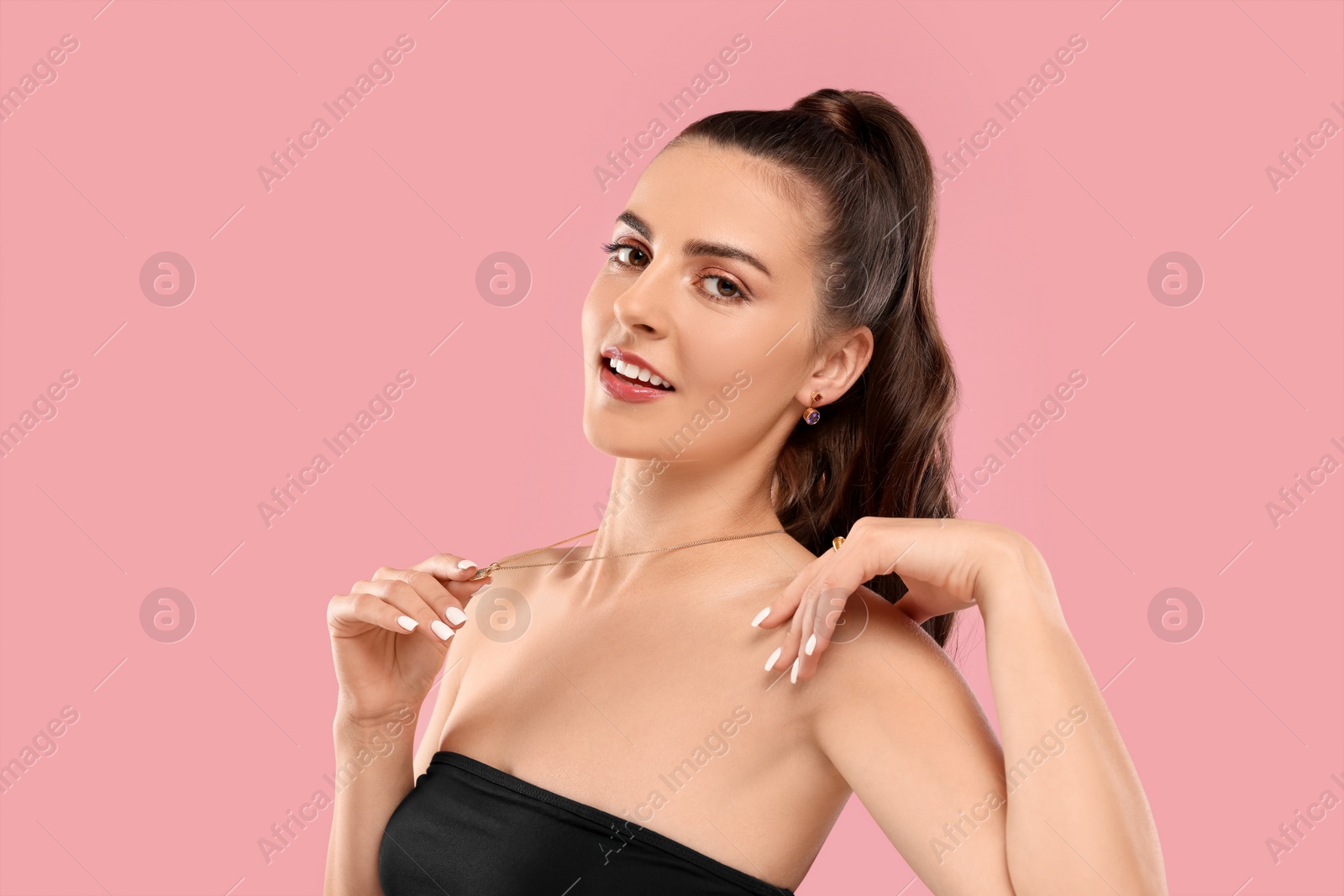 Photo of Beautiful woman with elegant jewelry on pink background