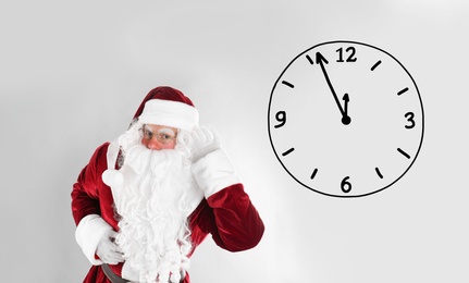 Image of Christmas countdown. Clock showing five minutes to midnight near Santa Claus on light background
