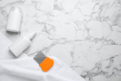 Photo of Products for anti lice treatment, metal comb and towel on marble background, flat lay. Space for text