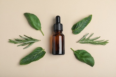 Photo of Little bottle of essential oil with different herbs on color background, flat lay