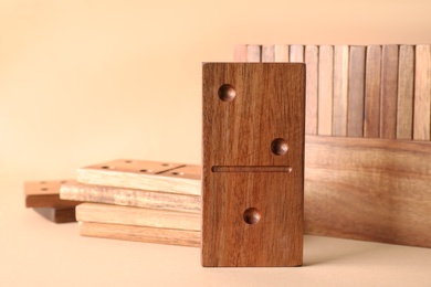 Photo of Set of wooden domino tiles on beige background