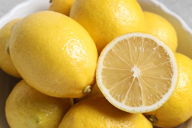 Photo of Fresh lemons in bowl, closeup. Citrus fruit