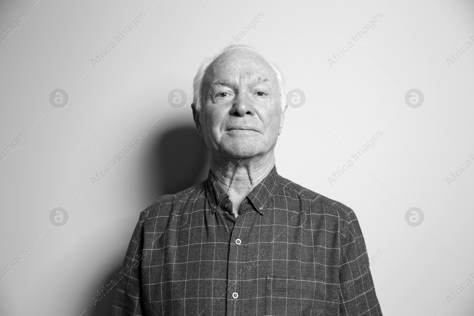 Photo of Portrait of elderly man on light background. Black and white effect