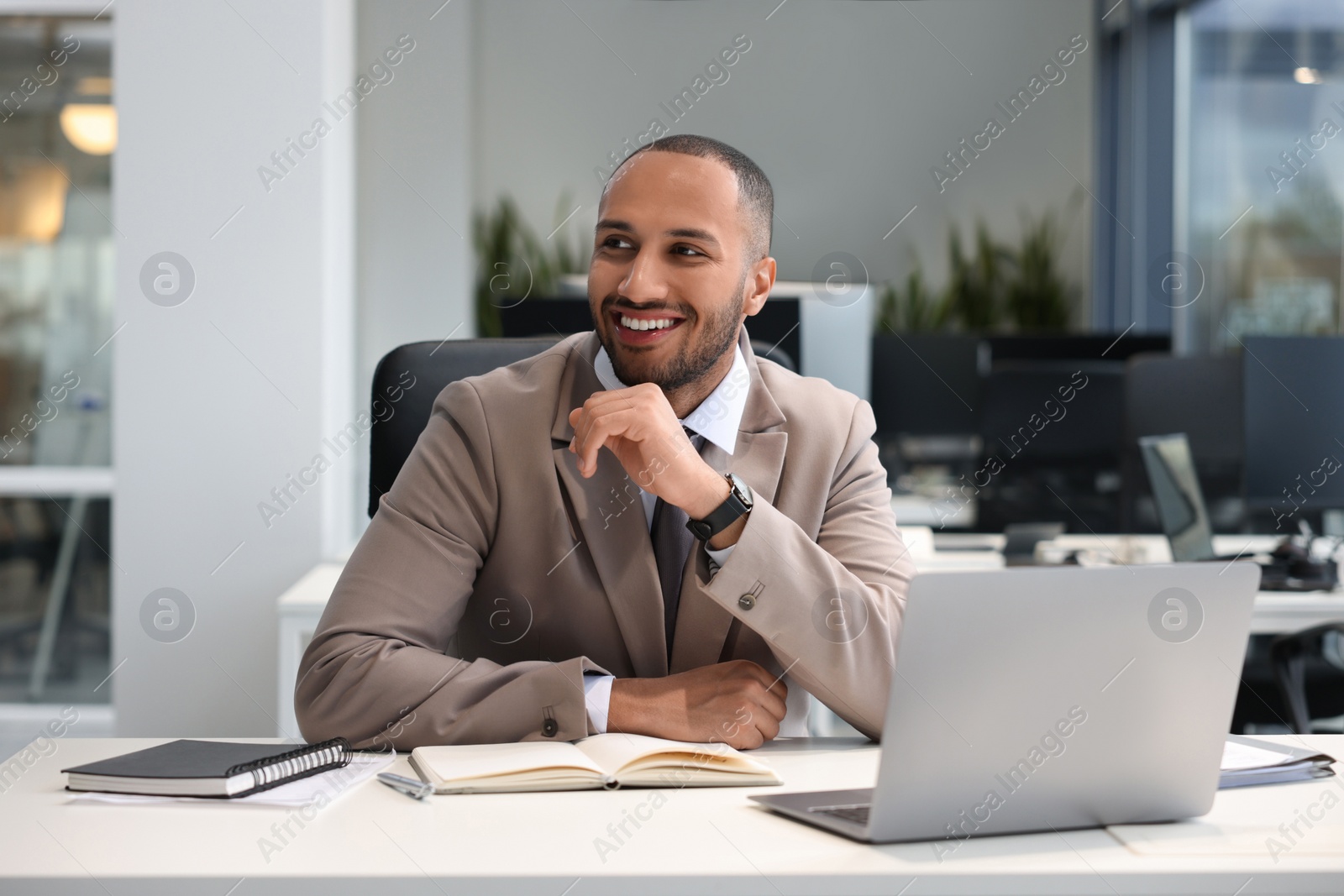 Photo of Happy man working at table in office. Lawyer, businessman, accountant or manager