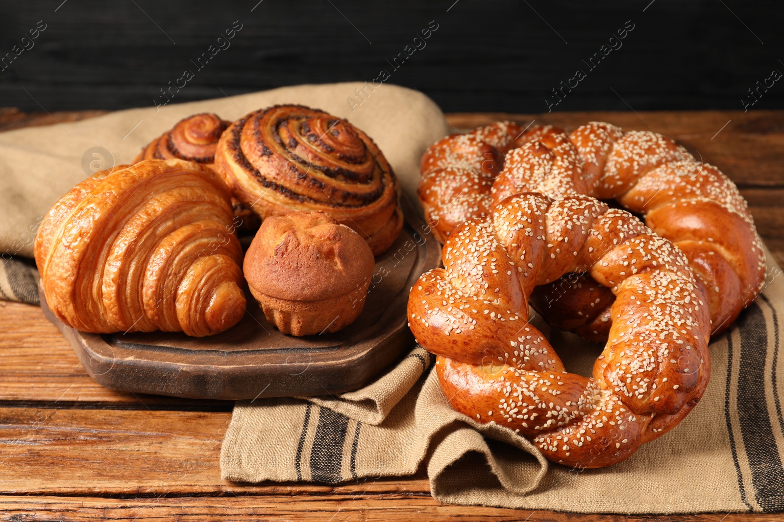 Photo of Different tasty freshly baked pastries on wooden table