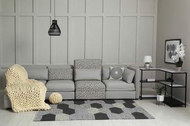 Photo of Living room interior with comfortable sofa near molding wall