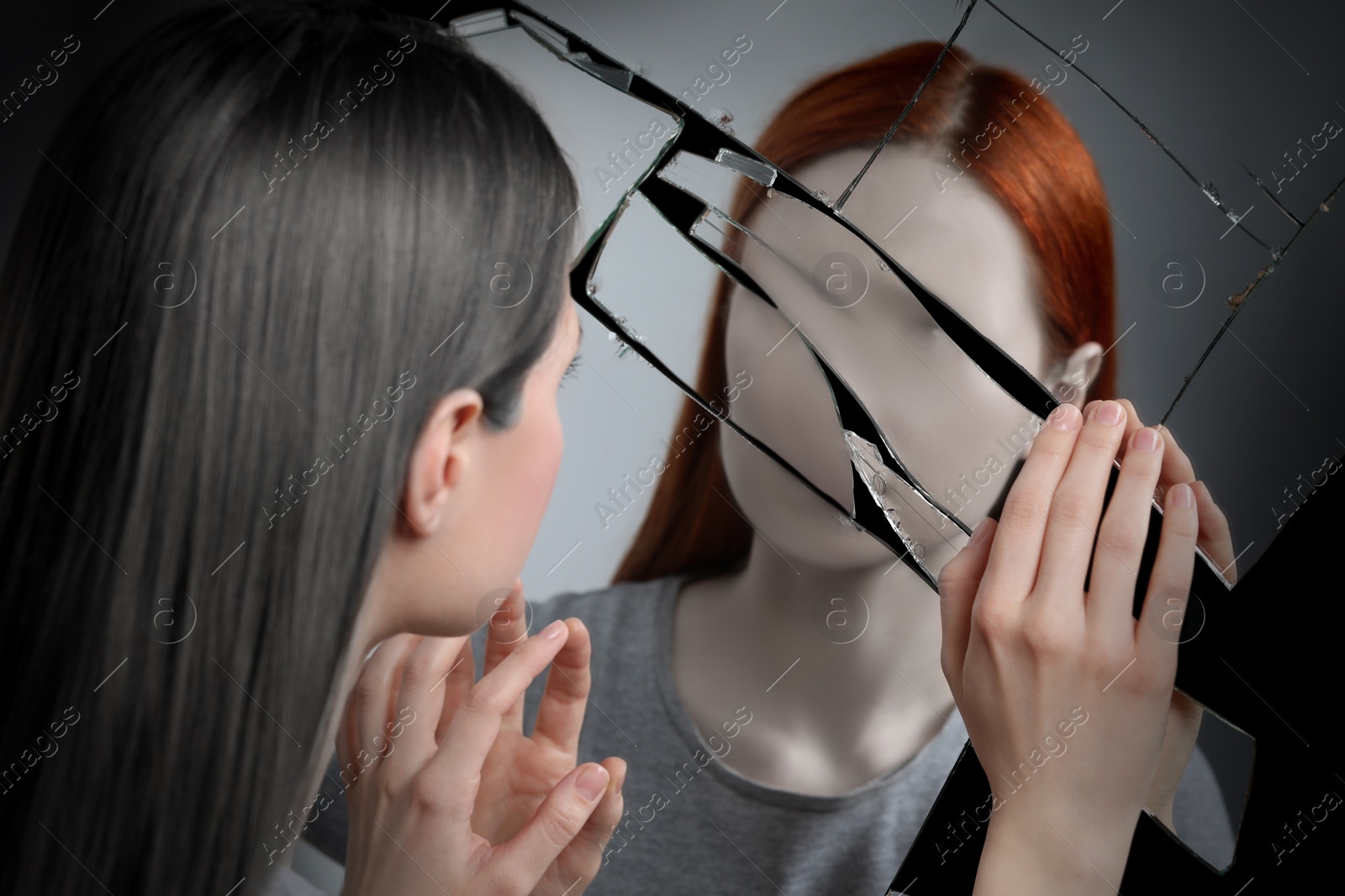 Image of Suffering from hallucinations. Woman seeing her faceless reflection in broken mirror