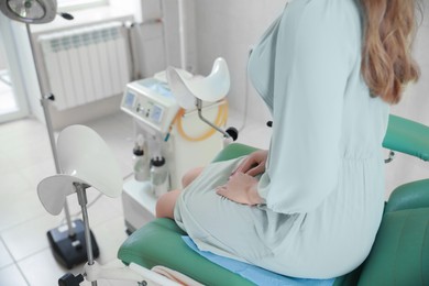 Photo of Gynecological checkup. Woman sitting on examination chair in hospital, closeup