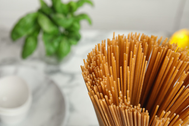 Photo of Uncooked buckwheat noodles on blurred background, closeup