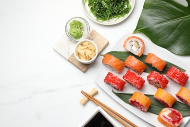 Photo of Flat lay composition with delicious sushi rolls on white marble table. Space for text