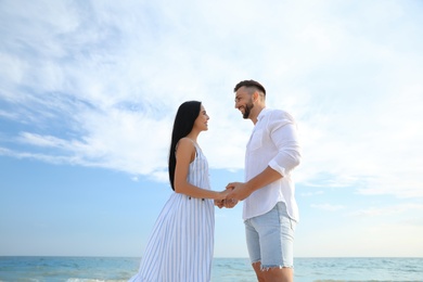 Photo of Happy young couple at beach on sunny day