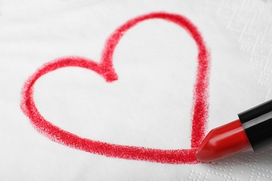 Photo of Drawing heart with lipstick on paper napkin