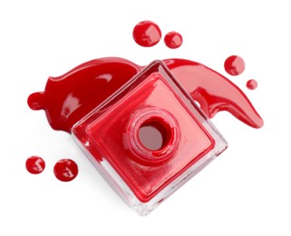 Photo of Bottle and spilled red nail polish isolated on white, top view