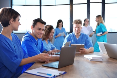 Photo of Group of smart medical students with gadgets in college