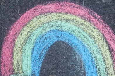 Child's chalk drawing of rainbow on asphalt, top view