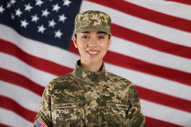 Photo of Female American soldier with flag of USA on background. Military service