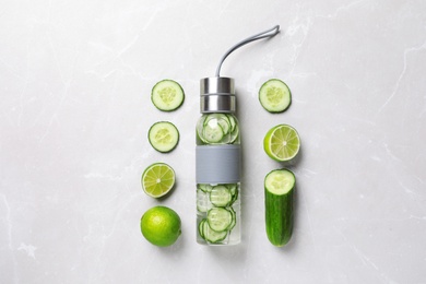 Photo of Flat lay composition with bottle of fresh  cucumber water on grey background