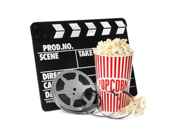 Photo of Popcorn, clapper and reel isolated on white. Cinema snack