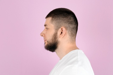 Photo of Young man with hearing problem on color background