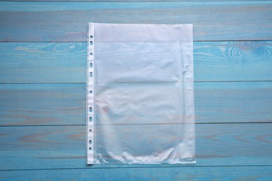 Photo of Punched pocket on light blue wooden table, top view