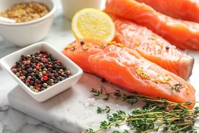 Photo of Fresh salmon and ingredients for marinade on marble board