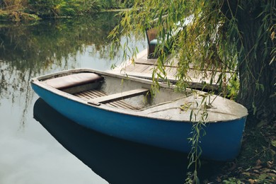 Photo of Light blue wooden boat on lake near pier