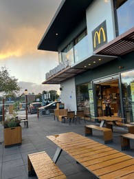 Photo of Leiden, Netherlands - October 15, 2023: Chairs and tables near McDonald's restaurant in city