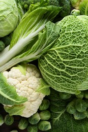 Many different types of fresh cabbage as background, top view