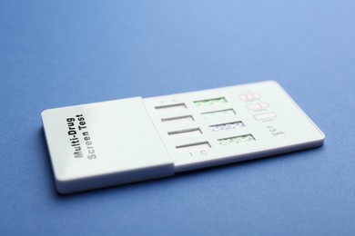 Photo of Multi-drug screen test on blue background, closeup