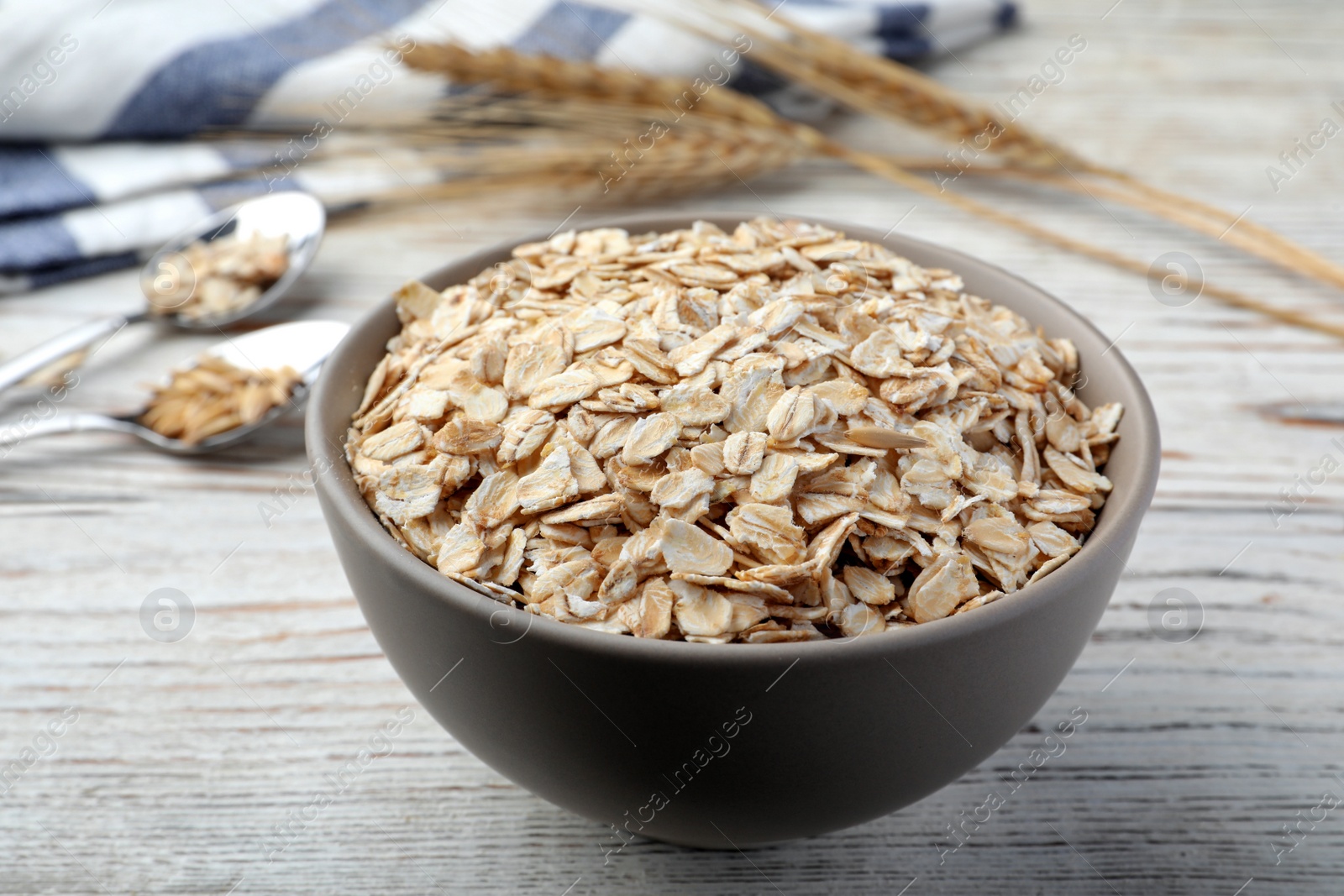 Photo of Bowl of oatmeal on white wooden table