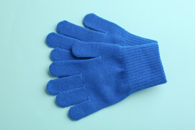 Photo of Pair of stylish woolen gloves on light blue background, flat lay