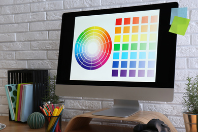 Photo of Modern computer and office supplies on wooden table. Designer's workplace