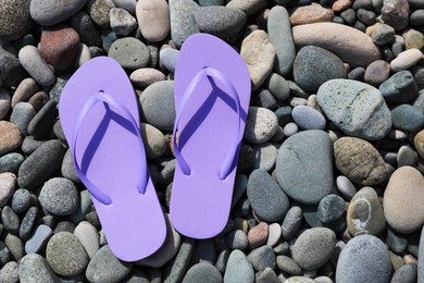 Photo of Stylish lilac flip lops on pebble beach, flat lay. Space for text