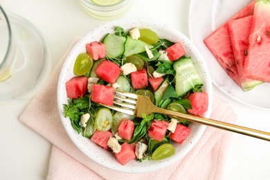 Photo of Delicious salad with watermelon served on white table, flat lay