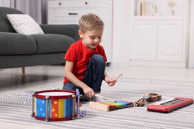 Photo of Little boy playing toy xylophone at home