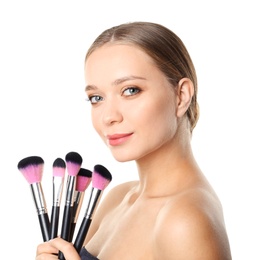 Photo of Portrait of beautiful young woman with makeup brushes on white background