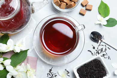 Photo of Flat lay composition with tea and fresh jasmine flowers on light grey marble table