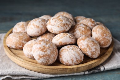 Photo of Plate with tasty homemade gingerbread cookies on blue table, closeup