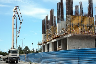 Photo of Modern truck with concrete pump near construction site