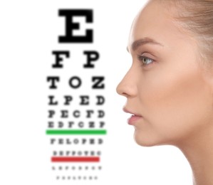 Image of Young woman and blurred eye chart on background. Visiting ophthalmologist 