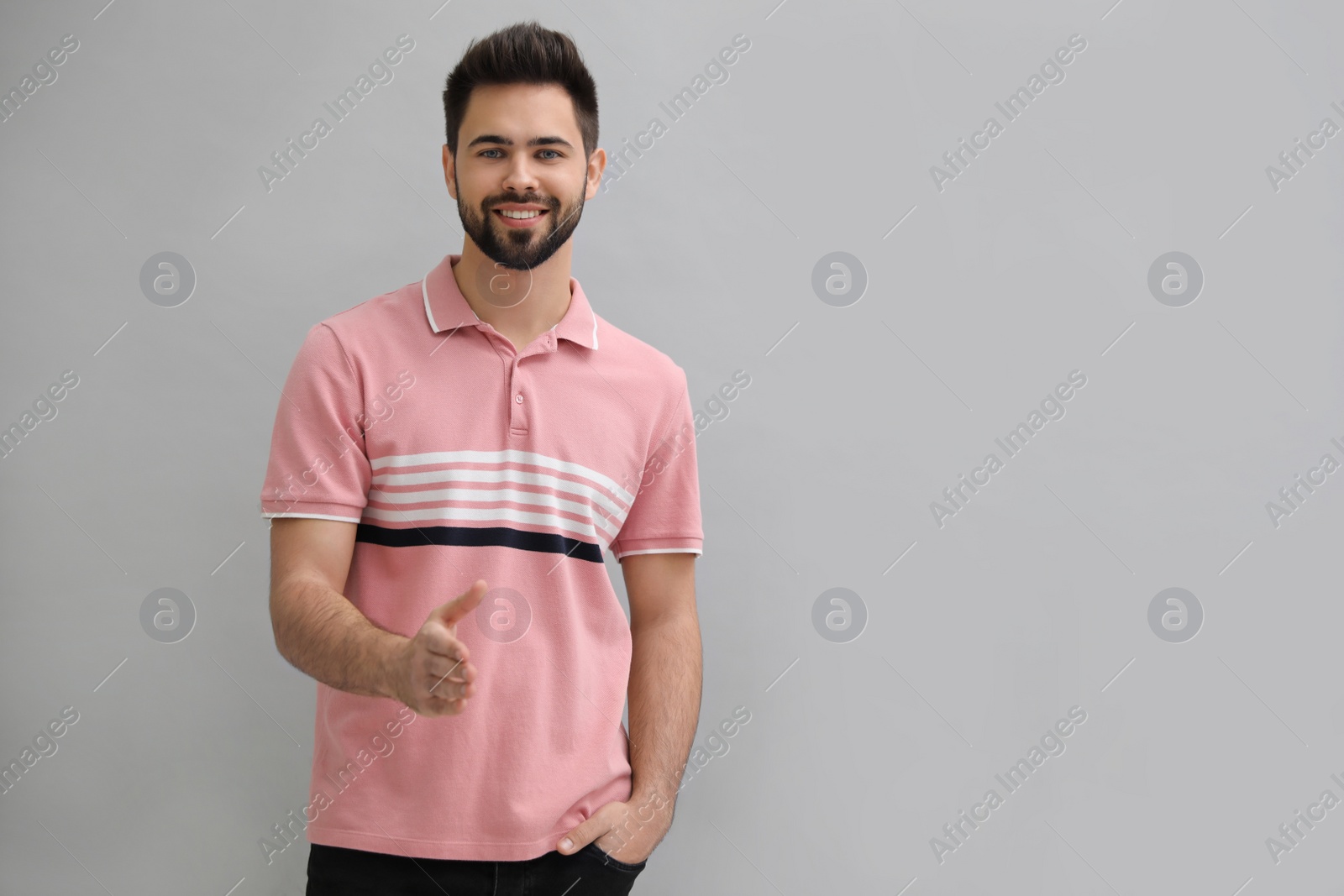 Photo of Man offering handshake on light grey background, space for text