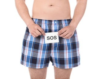 Photo of Young man with urological problems holding SOS sign on white background