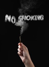 Image of No Smoking. Woman holding cigarette on black background, closeup. Phrase of smoke