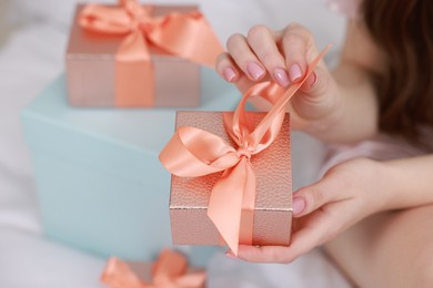 Woman with gift box indoors, closeup view